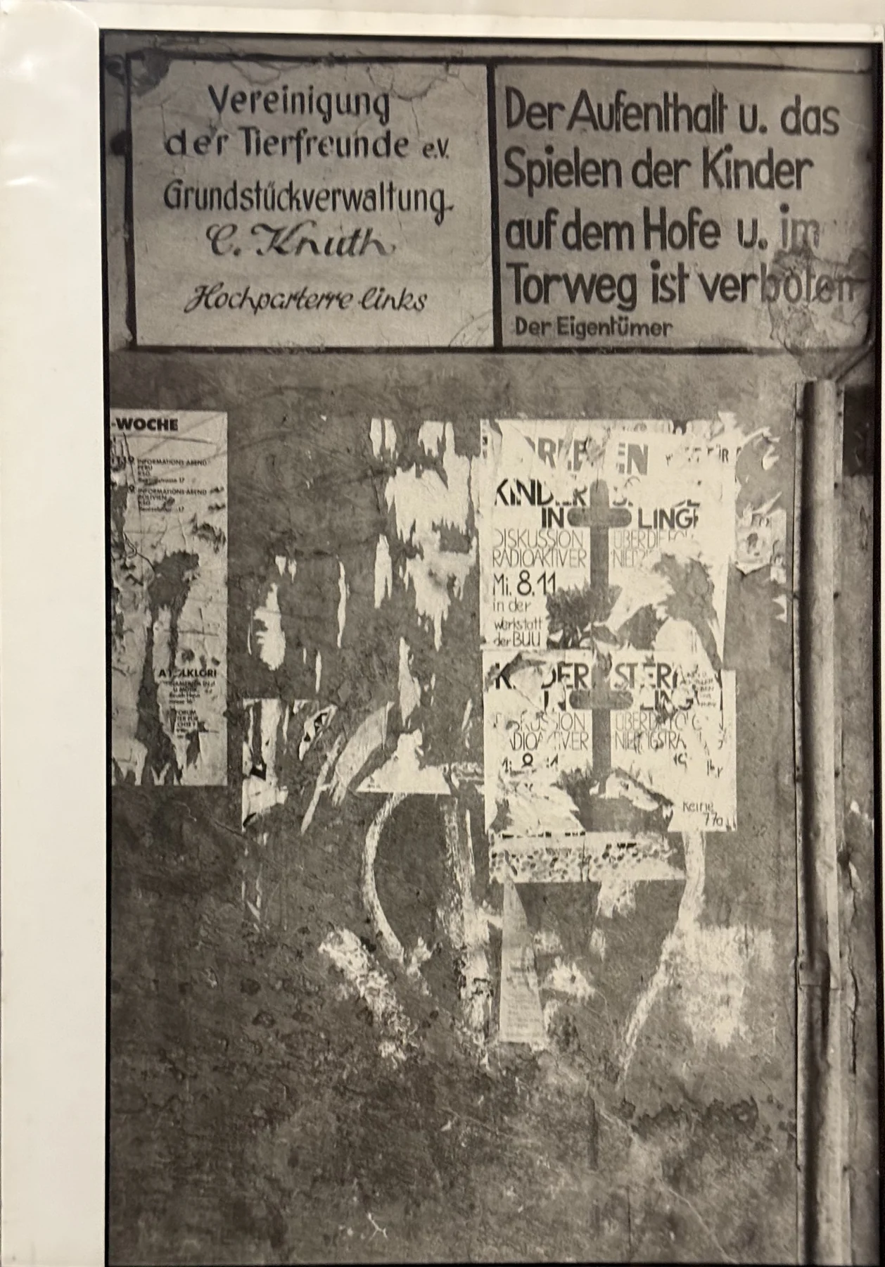 Aushänge, gerissenes Papier und abgenutzter Putz schichten sich zu einer Bildfläche aus Schrift und Spuren.